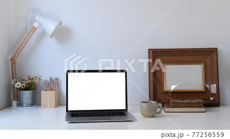 Creative designer workspace with white blank screen computer laptop and equipment on white desk. Creative designer workspace with white blank screen computer laptop and equipment on white desk. 77256559