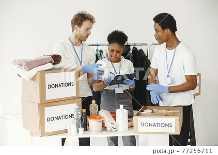 Two boys and a girl volunteers pack humanitarian aid 77256711