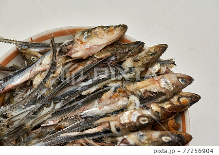 Fish heads and bones left after eating on a plate. Fish heads and bones left after eating on a plate. 77256904