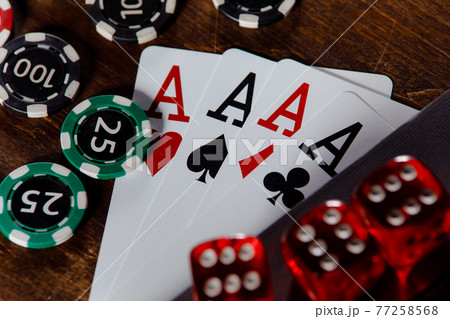 Playing chips, dices and cards on a wooden table close-up Playing chips, dices and cards on a wooden table close-up 77258568