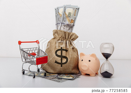 Dollar money bag, ohurglass and a shopping cart on white background Dollar money bag, ohurglass and a shopping cart on white background 77258585