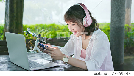 Asian student play mobile game 77259248