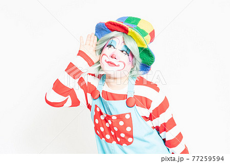 白背景の前で耳を澄ますジェスチャーをするピエロ 白背景の前で耳を澄ますジェスチャーをするピエロ 77259594