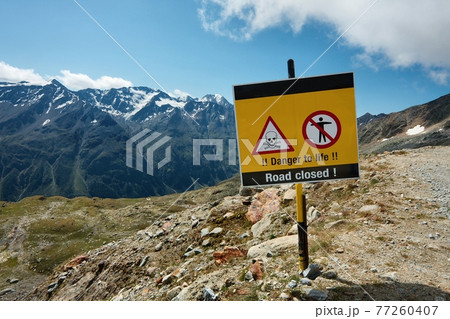 Path in the mountainsed closed with warning sign Path in the mountainsed closed with warning sign 77260407