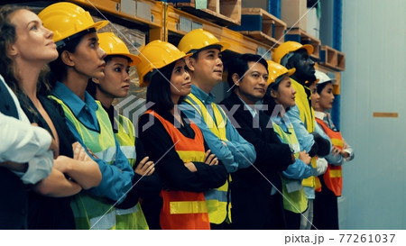 Large group of factory worker standing together in warehouse or storehouse 77261037