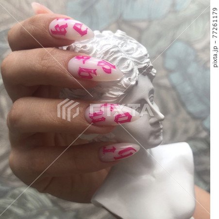 Stylish trendy female white manicure with design.Hands of a woman with white manicure on nails Stylish trendy female white manicure with design.Hands of a woman with white manicure on nails 77261179