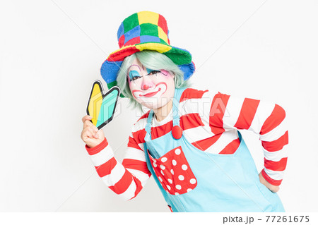白背景の前に立って 初心者マークを持つピエロの写真素材 白背景の前に立って 初心者マークを持つピエロの写真素材
