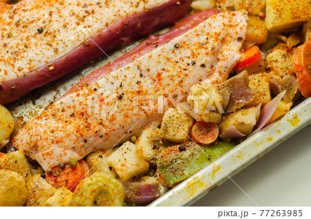 Raw duck breast with vegetables prepared on a metal baking tray 77263985