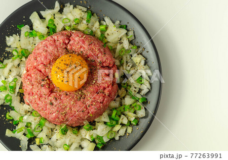 Beef steak tartare with raw egg yolk and onion with chive Beef steak tartare with raw egg yolk and onion with chive 77263991