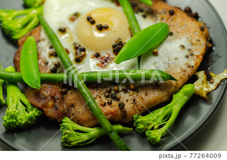 Fried portion of gammon served with egg, green beans, broccoli and sugar snap peas Fried portion of gammon served with egg, green beans, broccoli and sugar snap peas 77264009