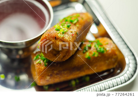 Delicious croquettes with sauerkraut and mushrooms served with hot red borscht on the silver tray 77264261