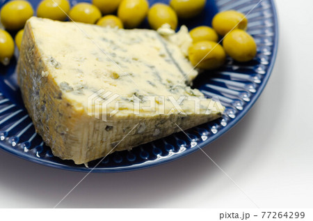 Full fat soft blue veined cheese and pickled olives stuffed garlic on the blue plate 77264299