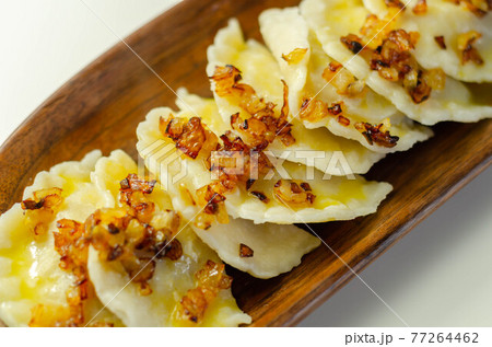 Close up of dumplings sprinkled with fried onion, traditional Polish, Russian and Ukrainian cuisine Close up of dumplings sprinkled with fried onion, traditional Polish, Russian and Ukrainian cuisine 77264462