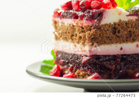 Colorful multi-layered cream chocolate cake with cherry jam and pomegranate 77264473