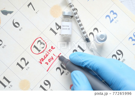 vaccine day concept glass ampoule with vaccine and syringe on calendar  77265996