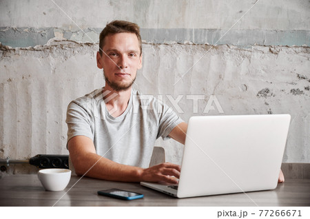 Smiling man working in laptop at home. Smiling man working in laptop at home. 77266671