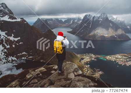 Man traveler taking photo with a smartphone hiking on Reinebringen mountain ridge in Norway lifestyle adventure traveling Man traveler taking photo with a smartphone hiking on Reinebringen mountain ridge in Norway lifestyle adventure traveling 77267474