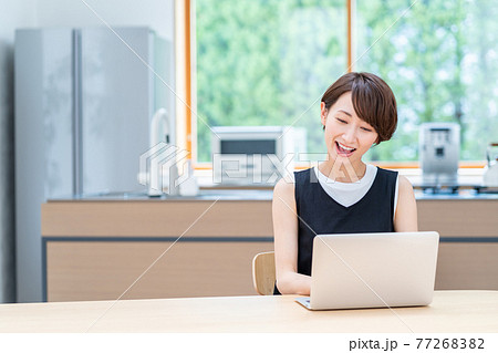 リビングでノートPCを使うミドル女性。 77268382