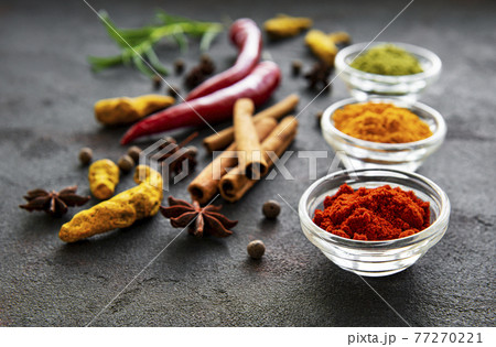 Various spices in a bowls on a black 77270221