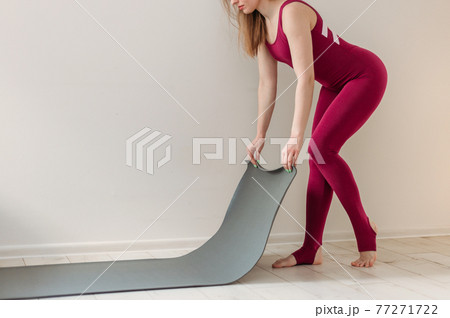 Yoga at home active lifestyle woman rolling exercise mat in living room for meditation yoga. Indoor and outdoor workout. Sport and healthy active lifestyle concept. 77271722