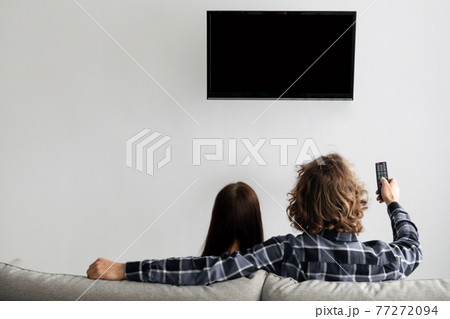 Family Watching TV Sitting On Couch At Home, Rear View 77272094