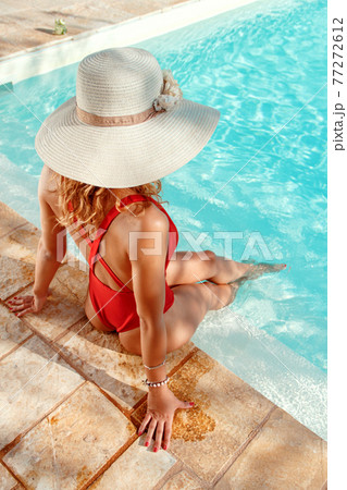 Young woman in red swimsuit and straw hat Young woman in red swimsuit and straw hat 77272612