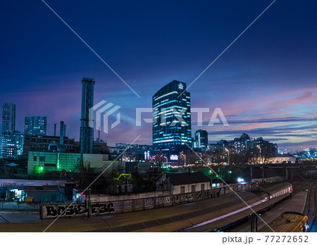 Night panorama with a view of the skyscraper Business Center 101 tower and a high chimney of the Kiev combined heat and power plant against the background of city lights and the sky at sunset 77272652