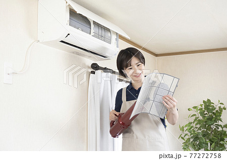 エアコンのフィルターの清掃をするハウスクリーニングの女性作業員 エアコンのフィルターの清掃をするハウスクリーニングの女性作業員 77272758