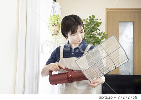 エアコンのフィルターの清掃をするハウスクリーニングの女性作業員 エアコンのフィルターの清掃をするハウスクリーニングの女性作業員 77272759
