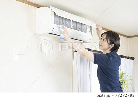 エアコンのフィルターの清掃をするハウスクリーニングの女性作業員 77272795