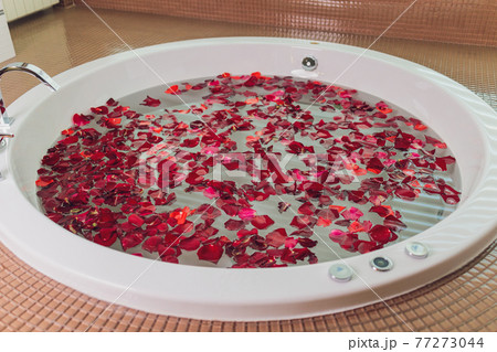 portrait of beautyfull hot pinup girl, red hair taking relaxing bath with flower petals on white copy space background , outdoor. 77273044