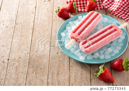 Strawberry popsicles on wooden table Strawberry popsicles on wooden table 77273343