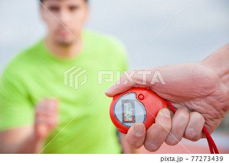 Runner and timer in running track 77273439