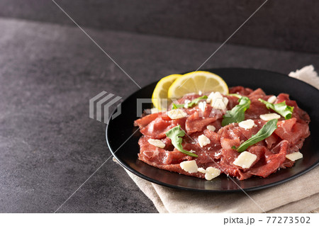 Marbled beef carpaccio on black plate 77273502