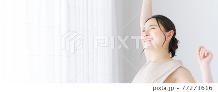 朝に伸びをする若い女性 77273616