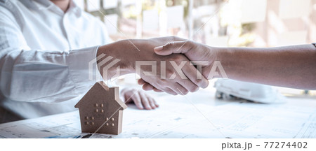 Team of architects or engineering shaking hands while working cooperation on engineer tools and construction drawings inspection, discussing planning architectural project on blueprint, model house 77274402