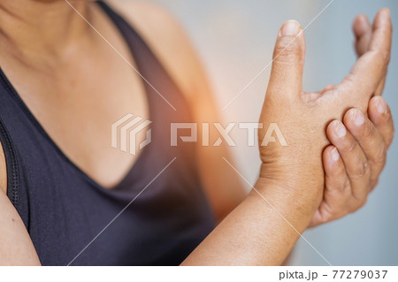 Asian middle-aged lady woman use elastic bandage to treating De Quervain syndrome at hand and finger in office.. 77279037