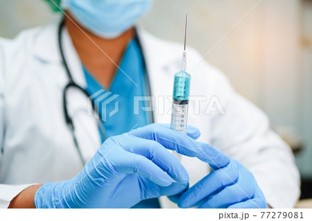 Doctor holding syringe with vaccine development medical for doctor use to treat illness patients at hospital. 77279081