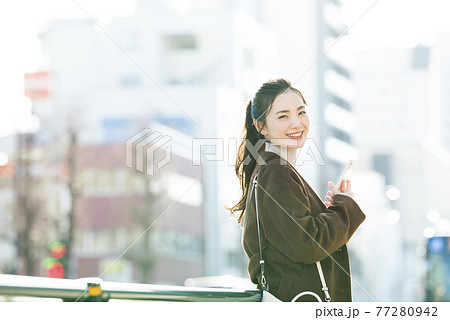 スマホで検索する若い女性 カメラ目線 スマホで検索する若い女性 カメラ目線 77280942