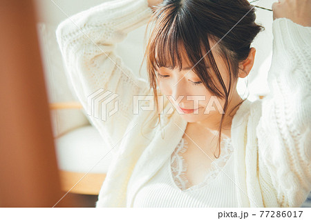 髪の毛をまとめる若い女性 髪の毛をまとめる若い女性 77286017
