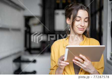 Housewife with tablet in the boiler room at home Housewife with tablet in the boiler room at home 77287578