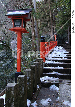 雪の残る参道 赤い灯篭 77287909