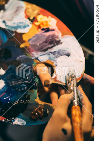 art school acrylic paint on palette brush in hands 77290504