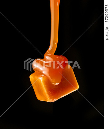 caramel sauce flowing on flying caramel candy caramel sauce flowing on flying caramel candy 77290578