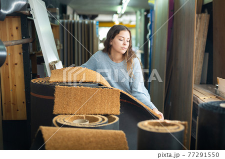 Woman consumer choosing carpet in hardware store 77291550
