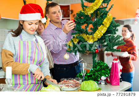 Woman cooking christmas dinner, family decoration christmas tree 77291879