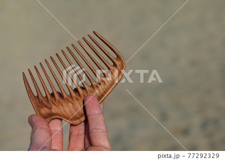 Handmade wooden comb for head massage and hair combing. Hair care concept. Handmade wooden comb for head massage and hair combing. Hair care concept. 77292329
