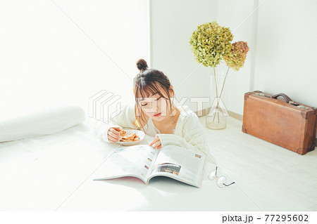 おやつを食べながら雑誌を読む女の子 おやつを食べながら雑誌を読む女の子 77295602