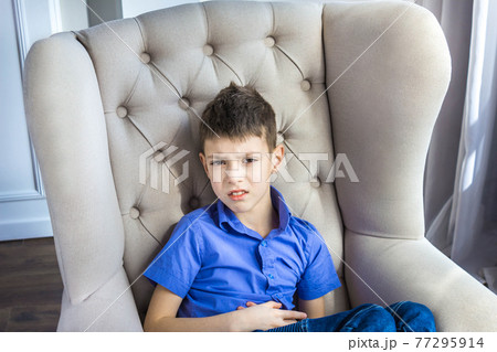 The disgruntled teen boy sitting at home The disgruntled teen boy sitting at home 77295914