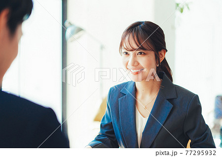 接客をするスーツの女性 77295932